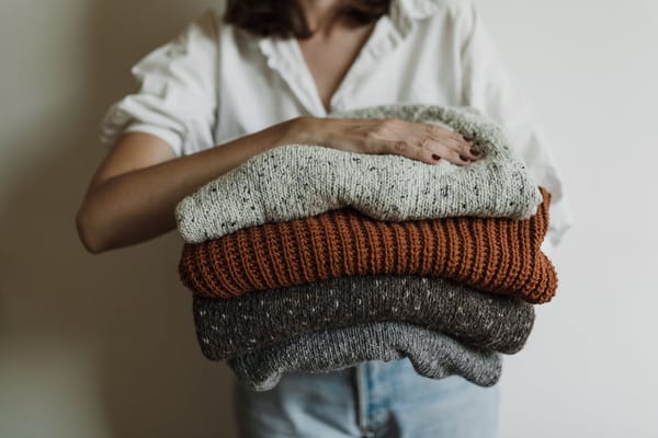Woman with a pile of sweaters